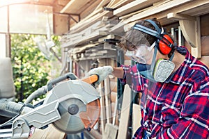 Young beautiful handy professional happy female strong carpenter portrait wearing protective goggles working in