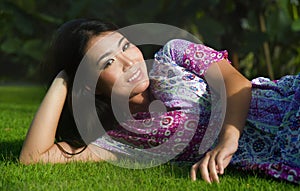 Young beautiful and happy Asian Chinese 20s woman lying relaxed