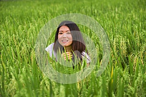 Young beautiful and happy Asian Chinese tourist girl having fun feeling free at tropical rice field enjoying exotic holidays trip