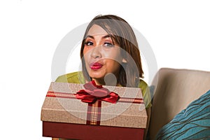 Young beautiful and happy Asian Indonesian woman holding birthday or Christmas present showing the gift box cheerful and excited