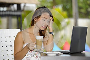 Beautiful happy woman in Summer dress outdoors at nice coffee shop having breakfast networking or working with laptop computer