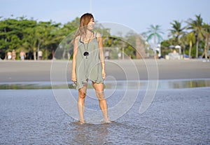 Young beautiful and happy Asian woman smiling relaxed having fun on tropical beach in Bali Asia