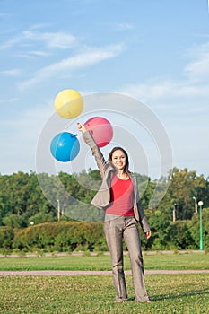 Young beautiful happy barefoot business woman with long hair with air balloons outdoor