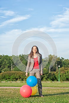 Young beautiful happy barefoot business woman with long hair with air balloons outdoor