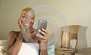 Young beautiful and happy black African American woman smiling excited using internet social media app on mobile phone networking