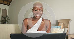 Young beautiful and happy black afro American woman smiling excited having fun on internet using social media on laptop computer