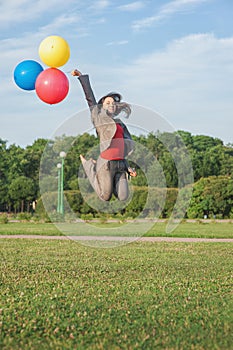 Young beautiful happy business woman with long hair jumping with air balloons outdoor