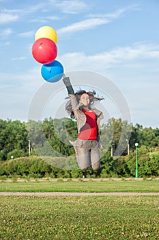 Young beautiful happy business woman with long hair jumping with air balloons outdoor