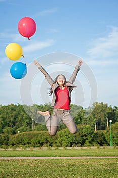 Young beautiful happy business woman with long hair jumping with air balloons outdoor