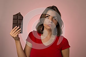 Young beautiful happy and excited woman holding big chocolate ba