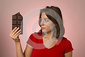 Young beautiful happy and excited woman holding big chocolate ba