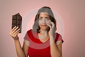 Young beautiful happy and excited woman holding big chocolate bar in sugar addiction temptation