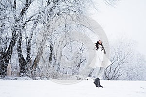 Young beautiful happy girl walking in park. Model wearing stylish winter clothing. Outdoor active fun.