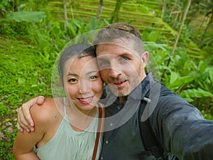 Young beautiful and happy mixed ethnicity couple beautiful Asian Chinese woman and white man in love taking selfie picture