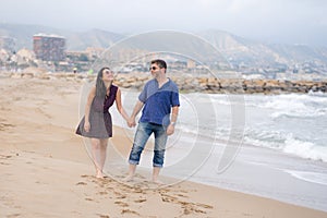 Young beautiful and happy mixed ethnicity couple of Asian woman and Caucasian man relaxed and cheerful walking playful  on beach