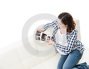 Young beautiful happy pregnant woman watching ultrasound scans