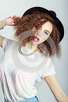 Young beautiful happy woman in a black hat, bright makeup, curly hair, fashion photography Studio on white background