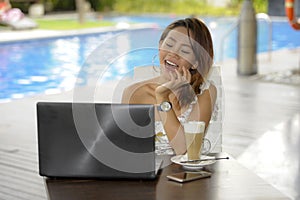 Beautiful happy woman in Summer dress outdoors at nice coffee shop having breakfast networking or working with laptop computer