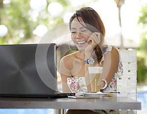 Beautiful happy woman in Summer dress outdoors at nice coffee shop having breakfast networking or working with laptop computer