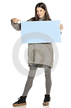 Young beautiful happy woman holding a blue empty board on white background