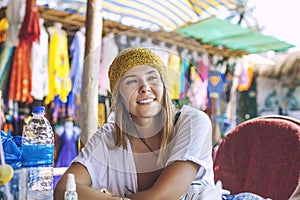 Young beautiful happy woman sitting in cafe on summer street mar