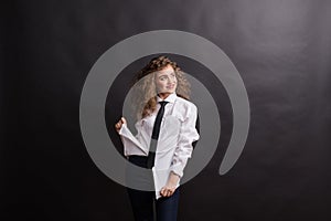 Young beautiful happy woman in studio, wearing white shirt and black tie.