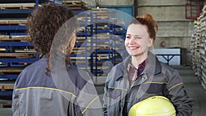 Young beautiful hardware storage female worker talking to her colleague