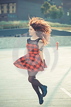 Young beautiful hipster woman with red curly hair