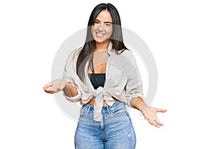 Young beautiful hispanic girl wearing casual clothes smiling cheerful with open arms as friendly welcome, positive and confident