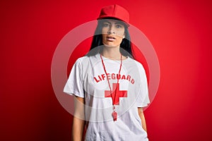 Young beautiful hispanic lifeguard woman wearing safeguard t-shirt and whistle with serious expression on face