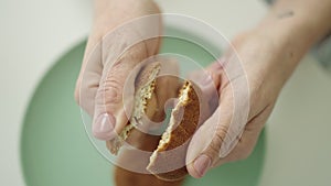 Young beautiful hispanic woman breaking a cookie at dinning room