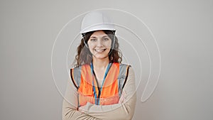 Young beautiful hispanic woman builder smiling confident standing with arms crossed gesture over isolated white background