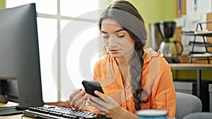 Young beautiful hispanic woman business worker having breakfast using smartphone at office