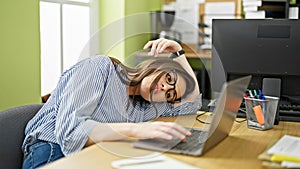 Young beautiful hispanic woman business worker looking watch leaning on table tired at office
