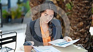 Young beautiful hispanic woman business worker reading document with relaxed expression at park