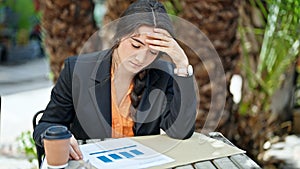 Young beautiful hispanic woman business worker reading document with relaxed expression at park