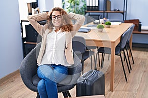 Young beautiful hispanic woman business worker relaxed waiting for travel at office