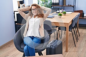 Young beautiful hispanic woman business worker relaxed waiting for travel at office