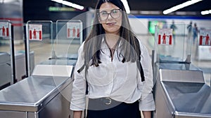 Young beautiful hispanic woman checking ticket on subway toll gate in subway station of Madrid