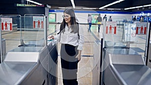 Young beautiful hispanic woman checking ticket on subway toll gate in subway station of Madrid