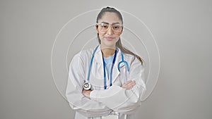 Young beautiful hispanic woman doctor smiling confident standing with arms crossed gesture over isolated white background