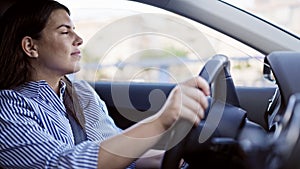 Young beautiful hispanic woman driving a car smiling on the road