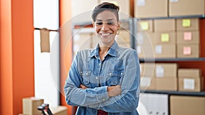 Young beautiful hispanic woman ecommerce business worker standing with arms crossed gesture at office