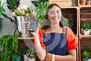 Young beautiful hispanic woman florist smiling confident holding data phone at florist