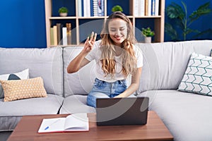 Young beautiful hispanic woman having video call communicate with sign deaf language at home