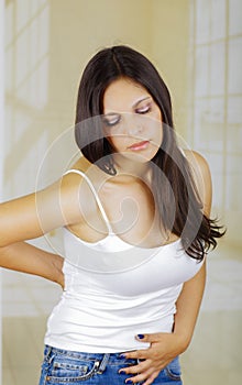 Young beautiful hispanic woman in painful expression touching her belly, suffering menstrual period pain, female health