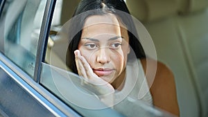 Young beautiful hispanic woman passenger sitting on car with relaxed face at park