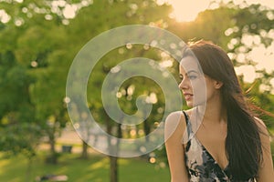 Young beautiful Hispanic woman relaxing in the park