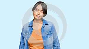 Young beautiful hispanic woman with short hair wearing casual denim jacket looking sleepy and tired, exhausted for fatigue and