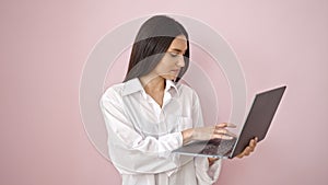 Young beautiful hispanic woman smiling confident using laptop over isolated pink background